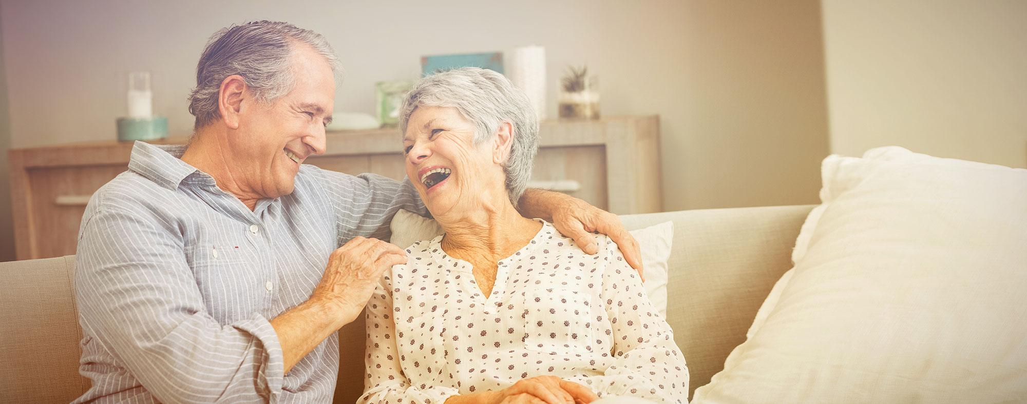 Senior couple sitting on the couch discussing a Reverse mortgage 